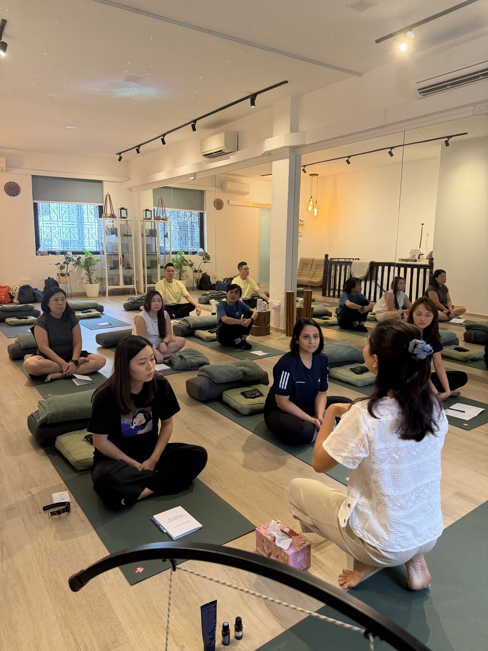 A Soulsound Asia guided session with a corporate team seated on mats and cushions in a studio